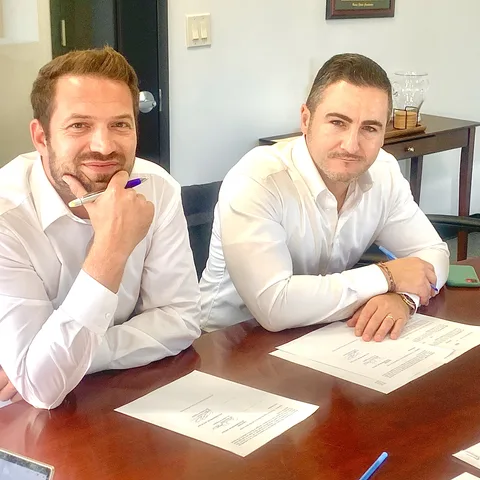 Bruce Elia Jr. going over deal paperwork with a client at a conference table