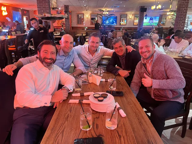Bruce Elia Jr. celebrating a closed deal over dinner with a group of clients